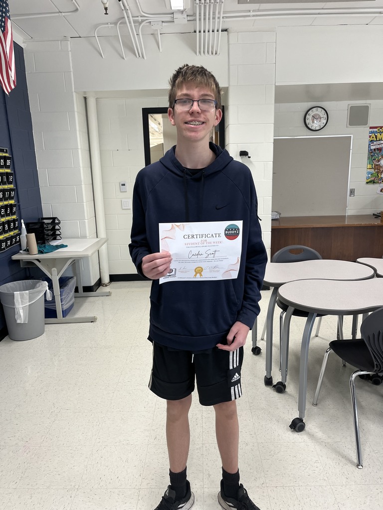 Student holding Student of the Week certificate