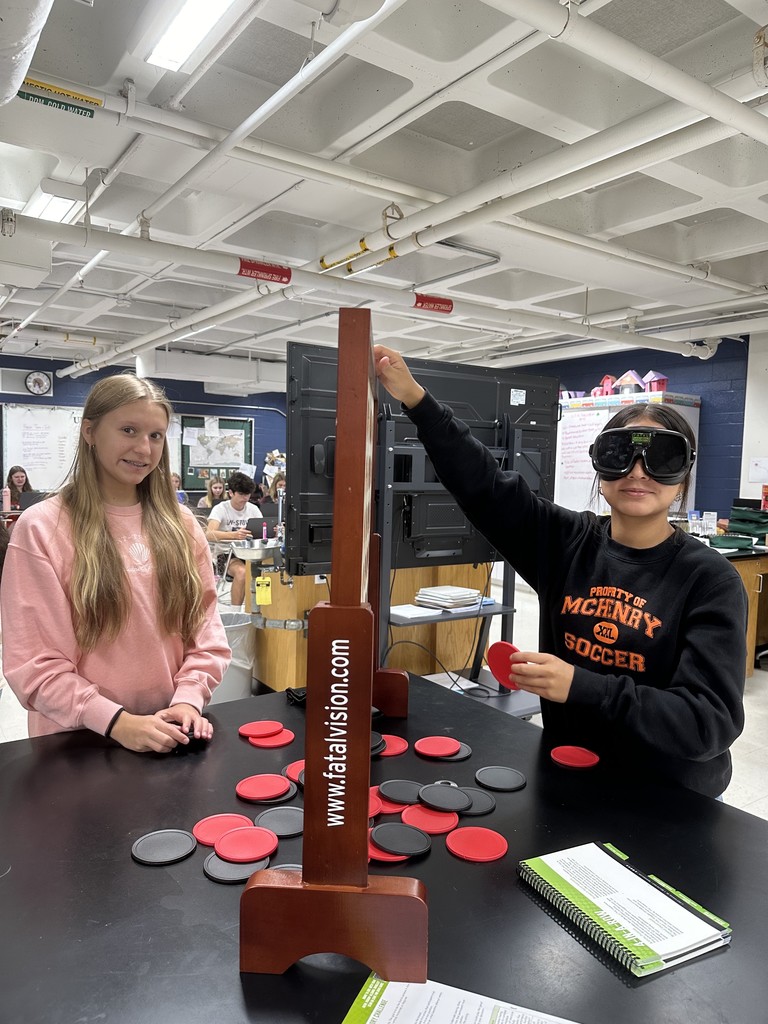 two students on wearing goggles and trying to play Connect Four