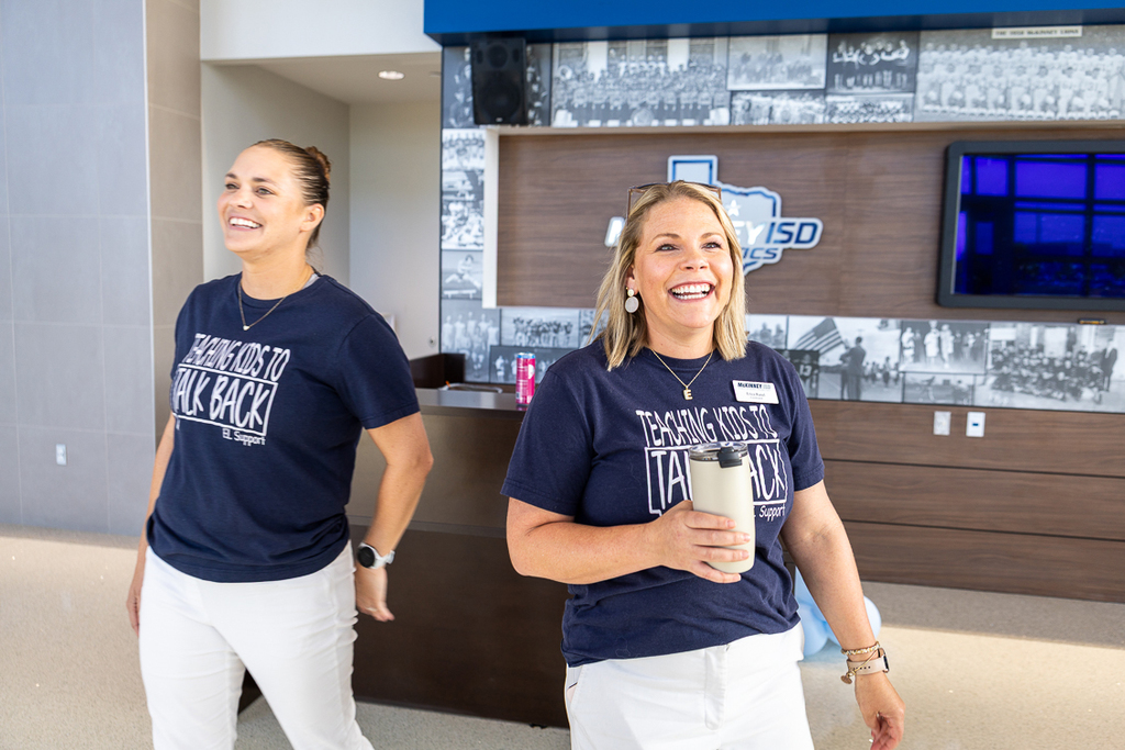 two female instructional coordinators greeting attendees as they arrive