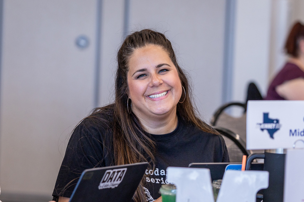 female teacher at table smiling at camera