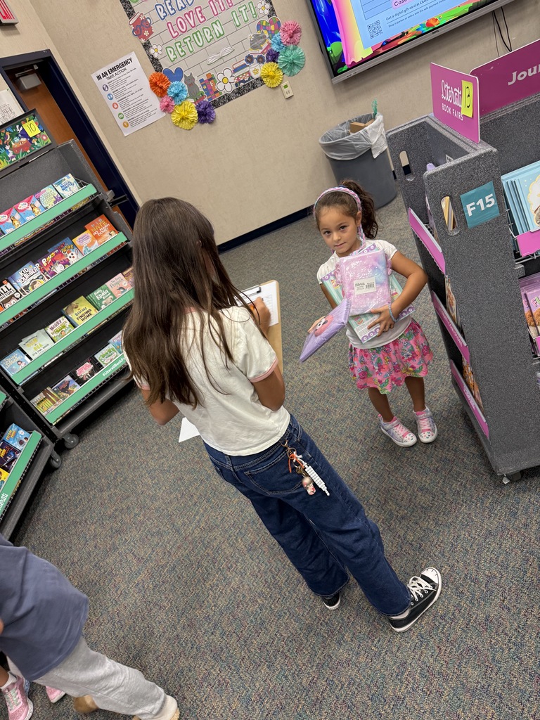5th graders helping kinder with Book Fair wishlists.