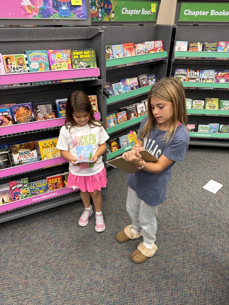 5th graders helping kinder with Book Fair wishlists.