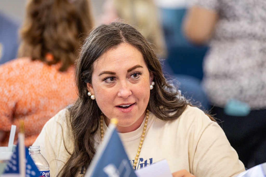 female participant seated at table talking