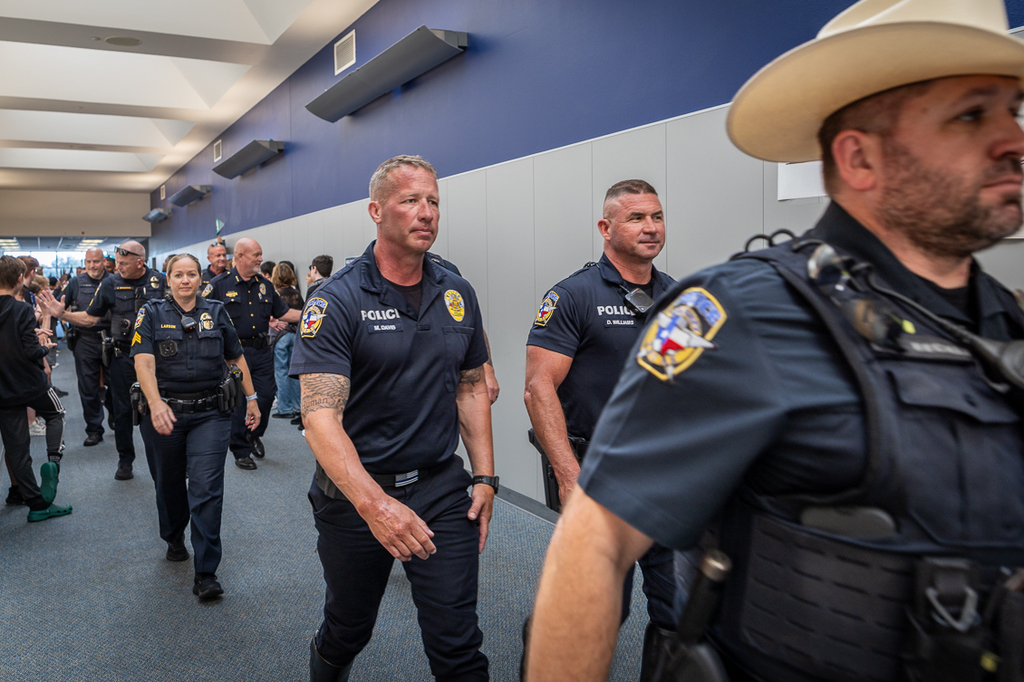 Police officers walking down a hall at Cockrill during parade