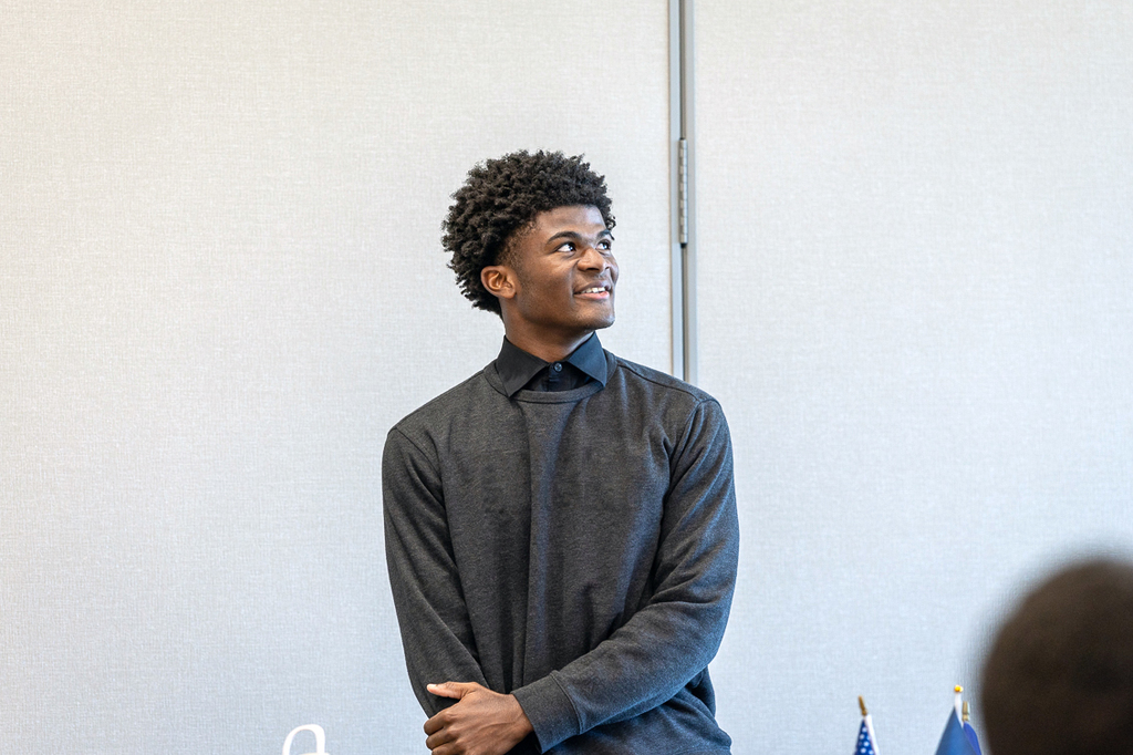 male student looking up and to his left and smiling
