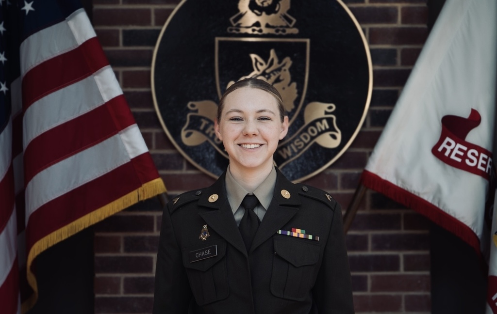 Campbell Chase in uniform between two flags