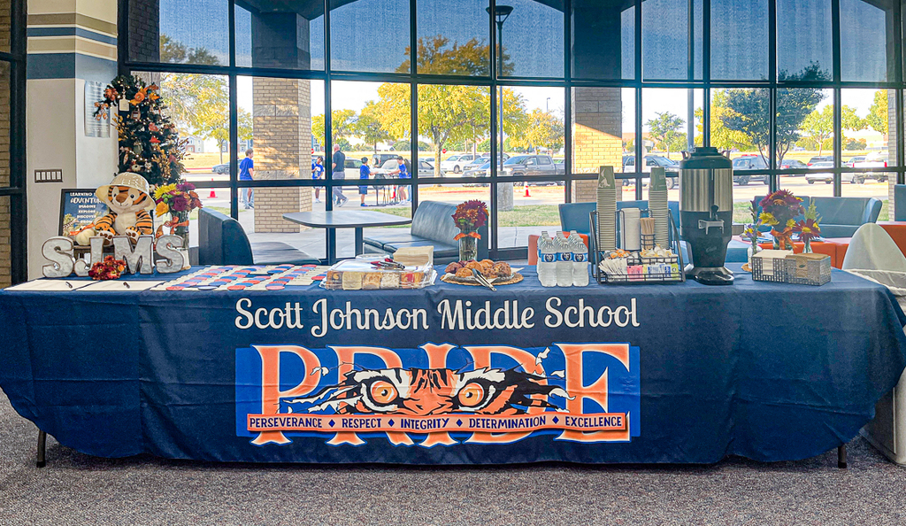 table of snacks with Scott Johnson Middle School and PRIDE logo across the front of the table cloth