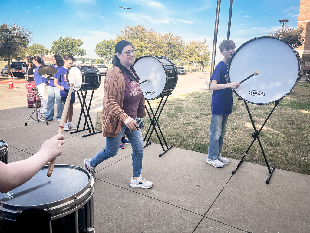 guest arriving and walking past the drum line toward the building