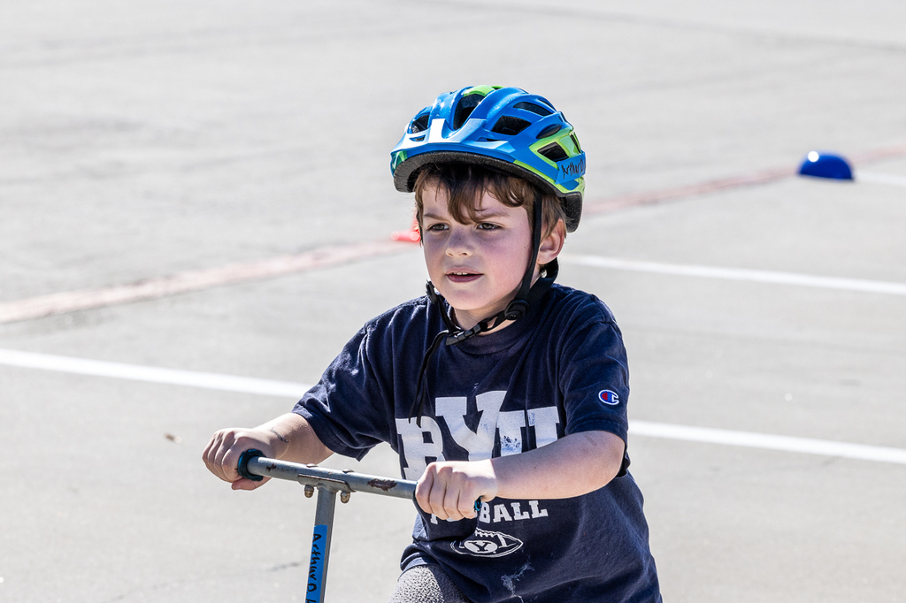 boy on scooter looking forward as he riding by