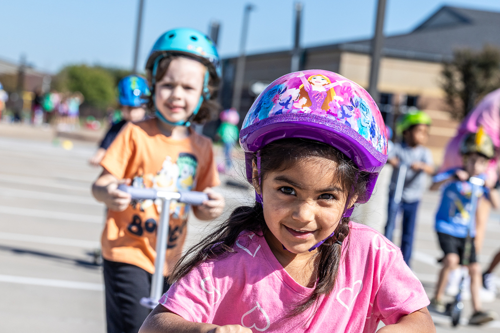 girl on scooter looking at camera as she rides past