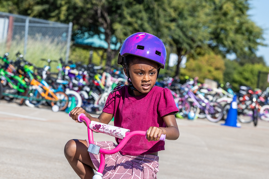 girl on bike riding by looking to the side