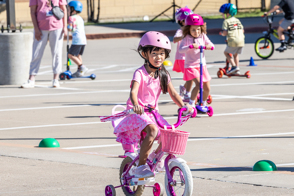 girl on bike riding by looking at camera
