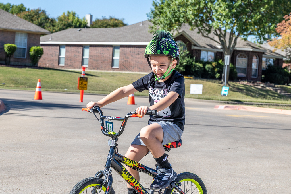 boy on bike with chin strap in his mouth