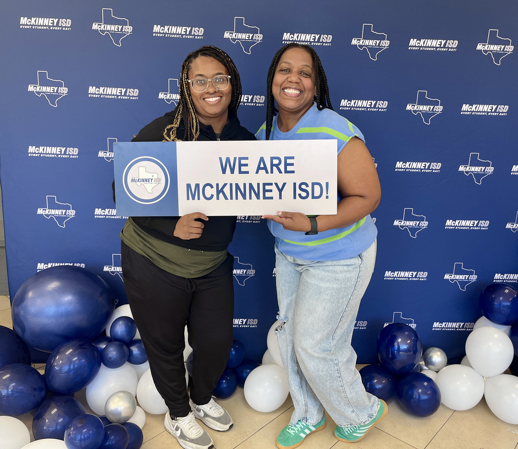two female teachers holding up we are mckinney isd sign
