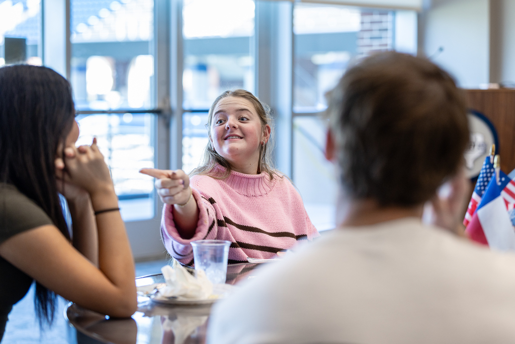female student pointing and smiling at another female student jokingly