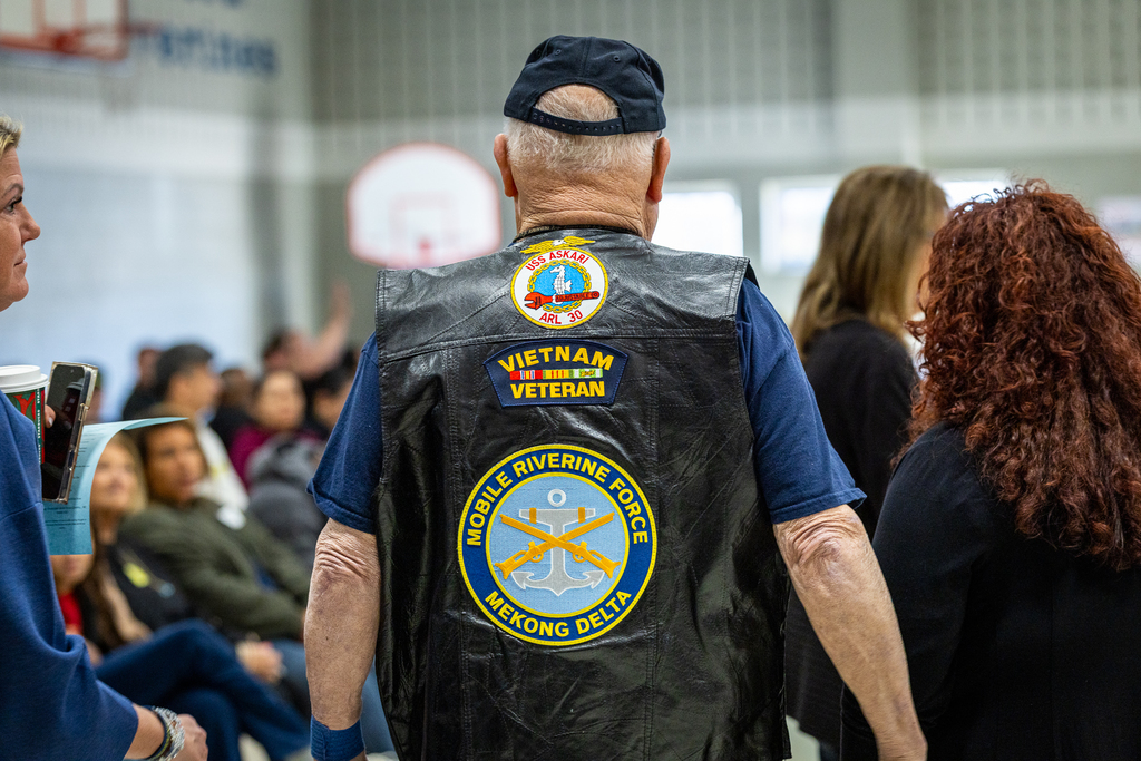 Back of the jacket of a male Vietnam veteran with service patches on it