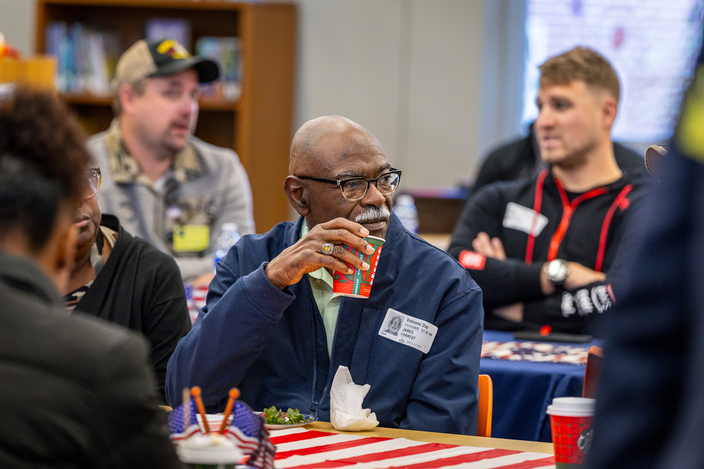 Veteran seated at table during reception in the library having a conversation