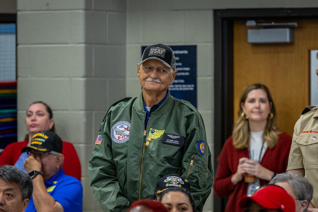 Veteran in US Air Force cap and jacket standing to be recognized