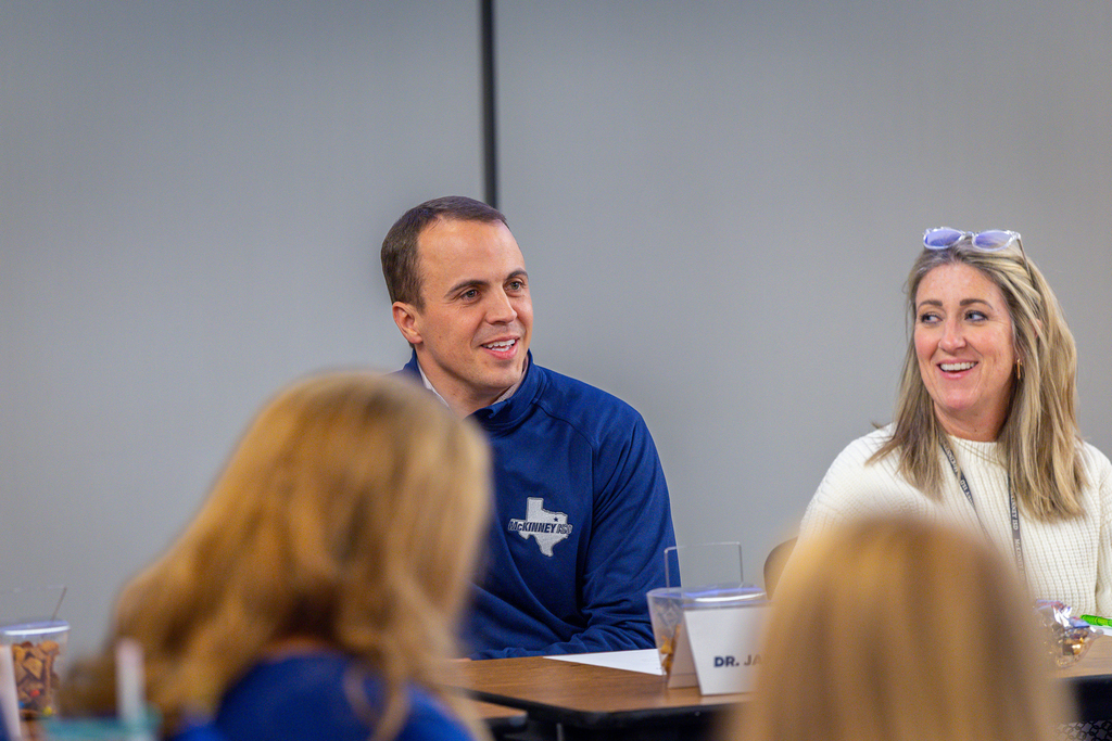 Jared Critchfield talking at the panel table while Wendy Cottam listens and laughs