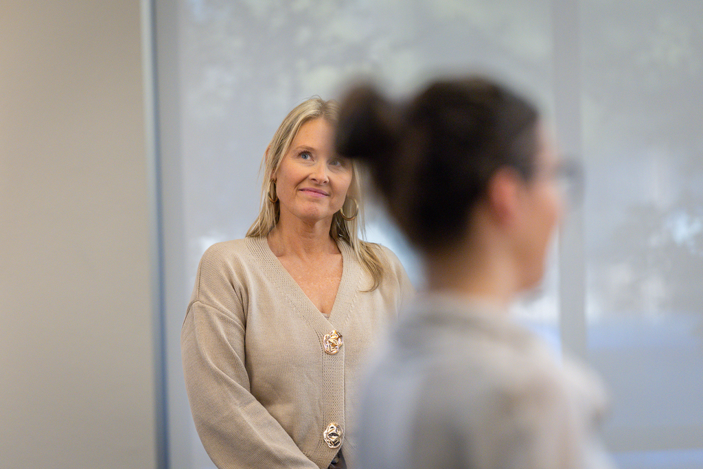 Dr. Shelly Spaulding smiles in the background as  participant speaks