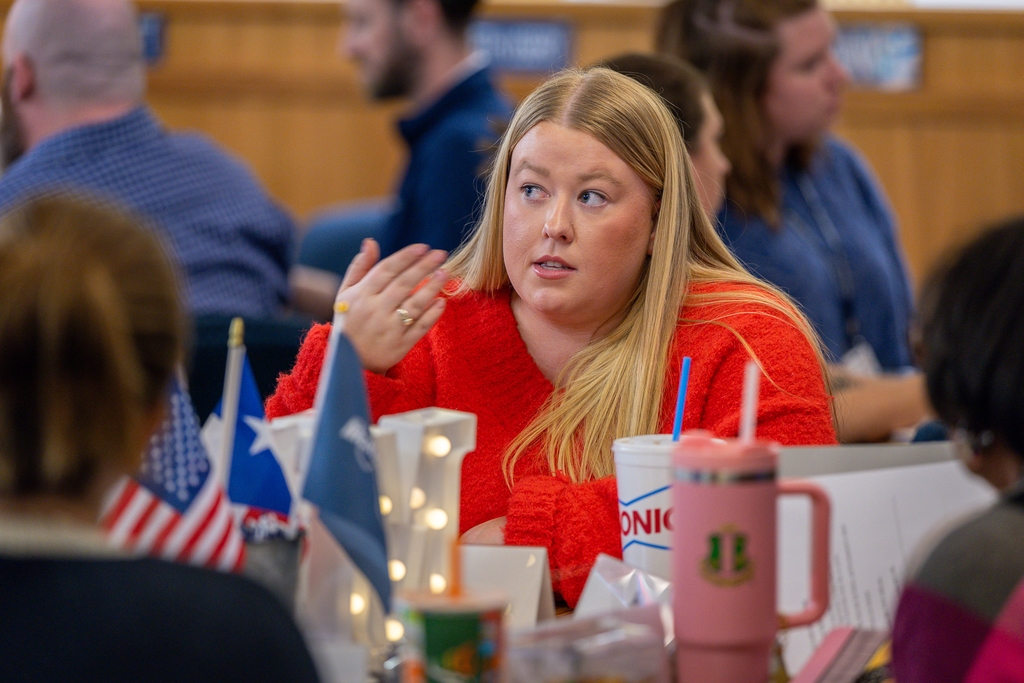 female participant talking at table and gesturing 
