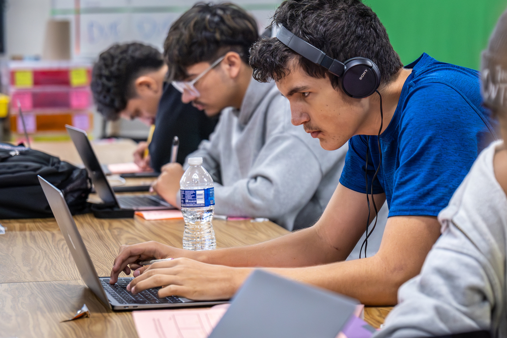 male student looking intently at computer as he works