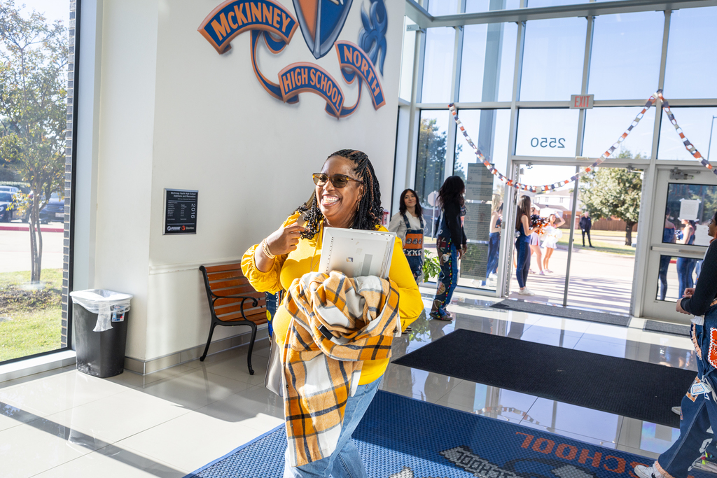 Woman walking through greeting groups smiling