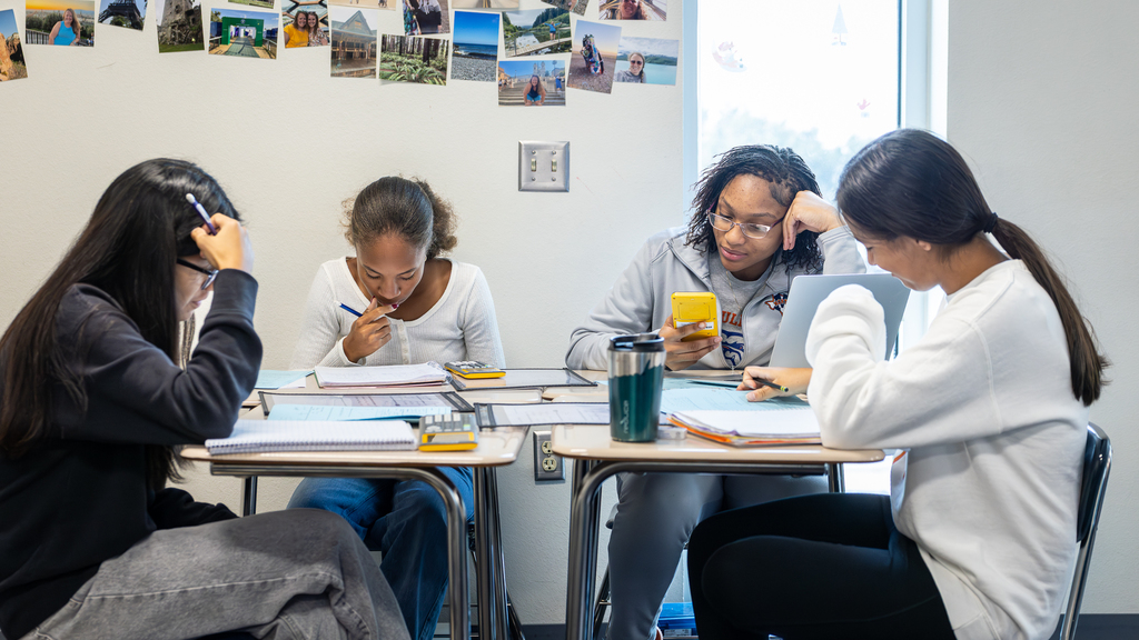 four girls at a table working on an assignment