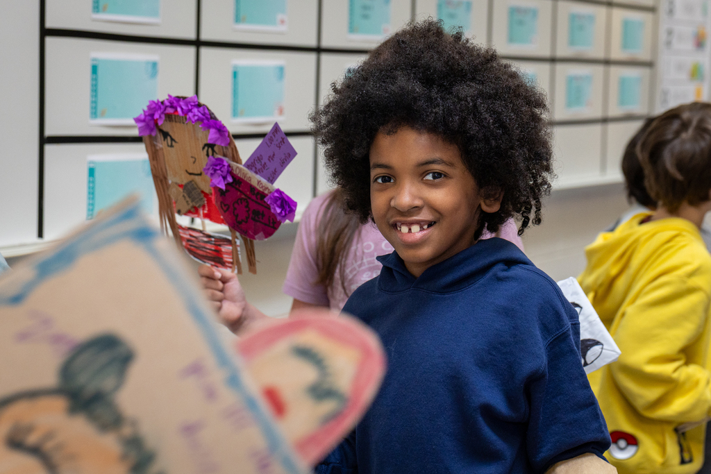 boy in line smiling and holding his decoration