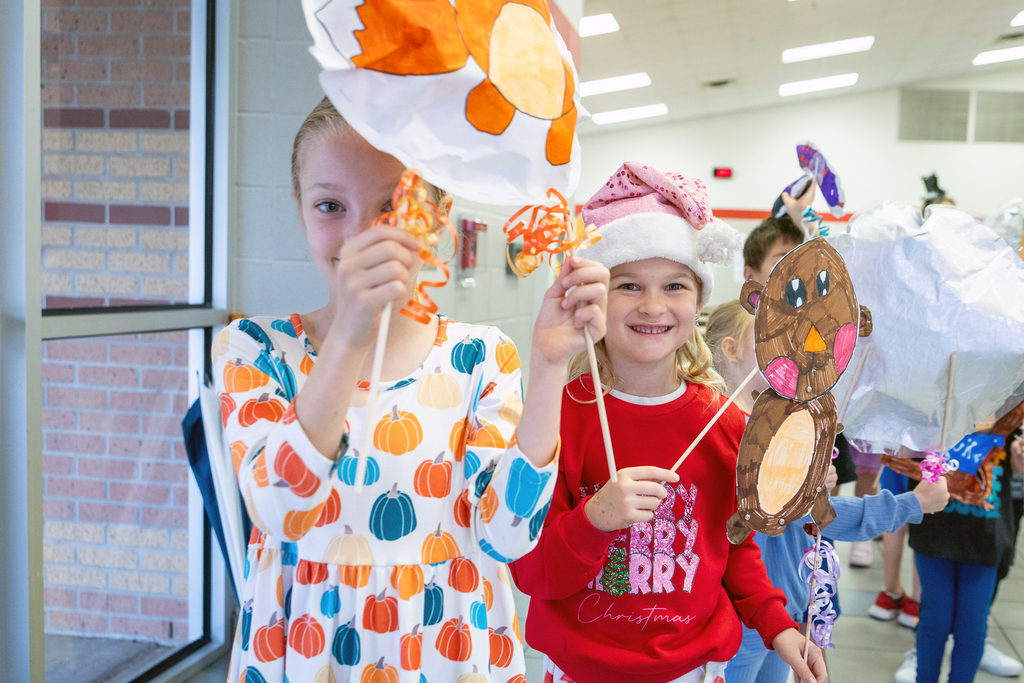 two girls in line smiling with decorations