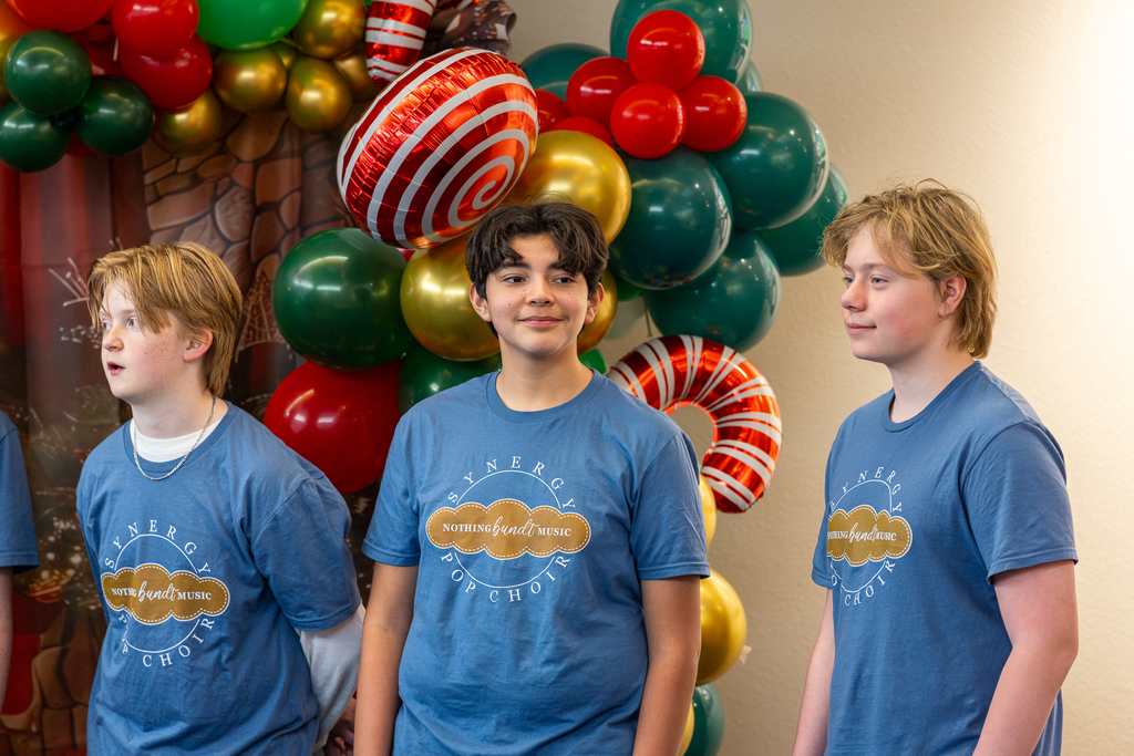 three boys in the choir smiling and one is looking toward the side and smiling