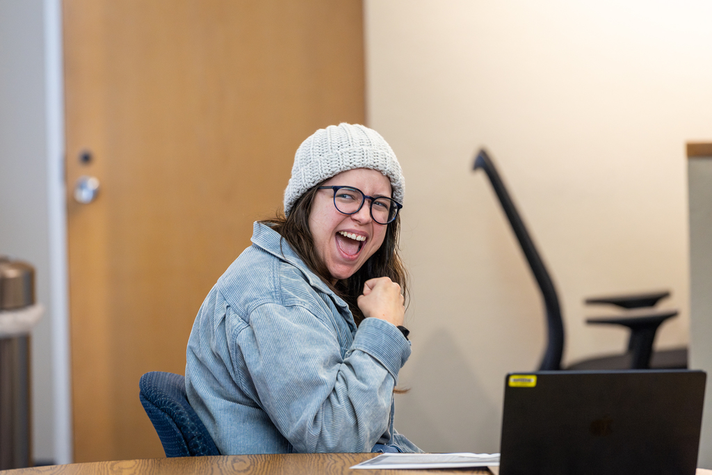 assistant director seated and smiling and gesturing with excitement