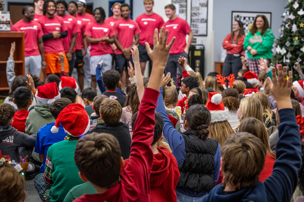 group of students in front of Ferris State team with one student raising his hand in the foreground