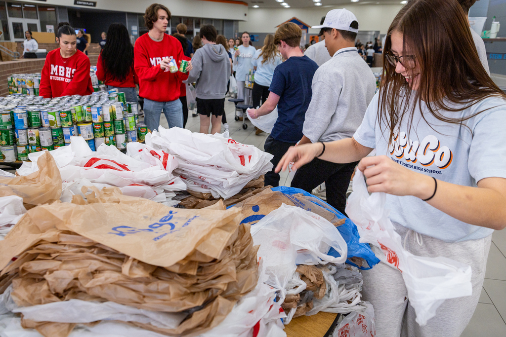 Girl from North handing out grocery bags and smiling