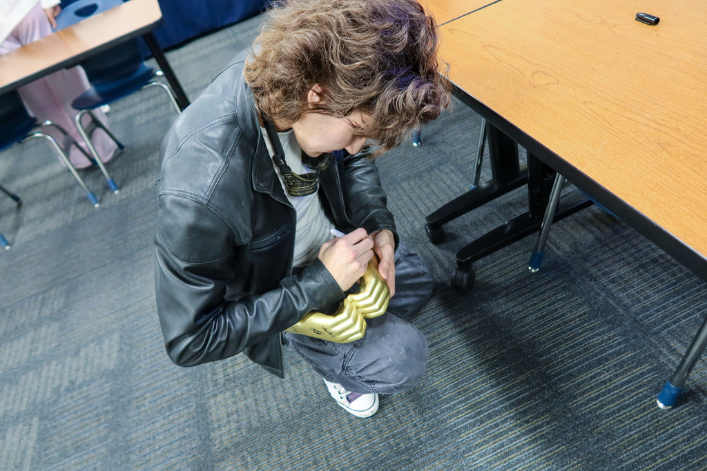 a student signs a gift for corey homer