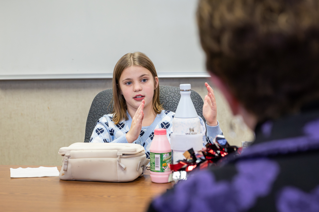 female student gesturing and asking a question of Sperry during lunch