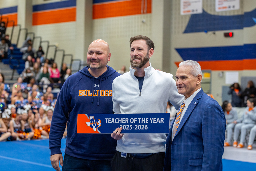 Justin Penio, Jacob Mannis and Oaxaca posing for photo with Mannis holding Teacher of the Year sign