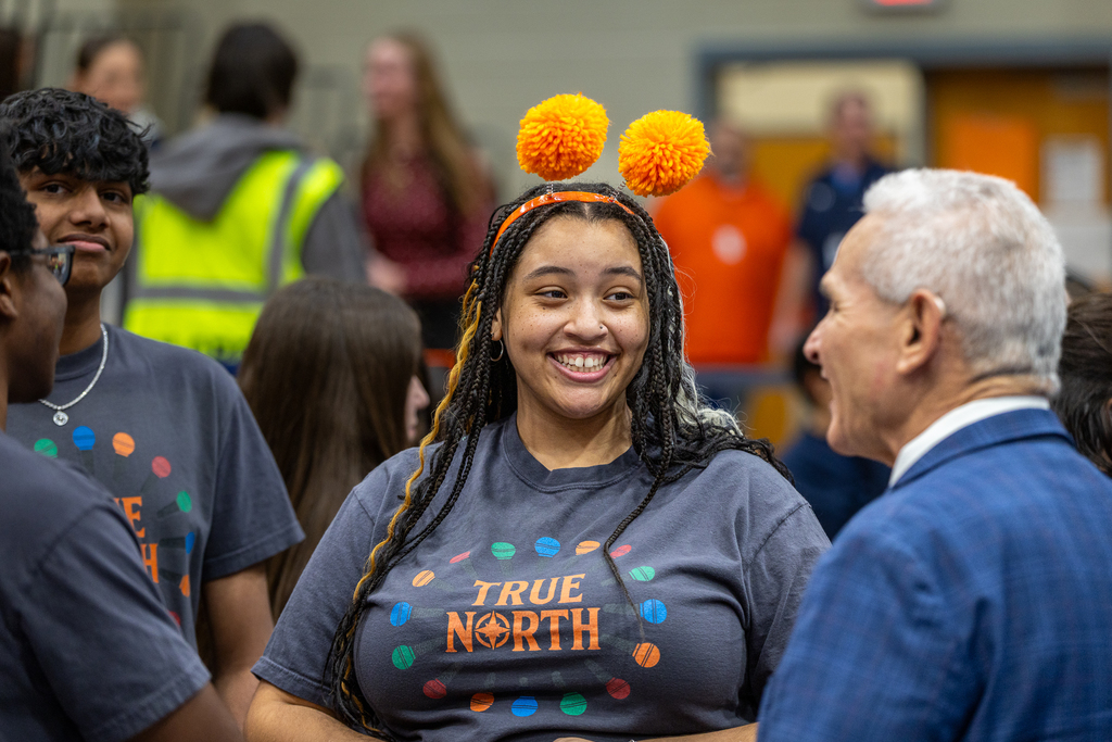 female member of the True North choir smiles at Oaxaca as he talks with a group of the singers