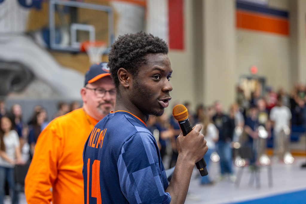 member of the soccer team with the microphone speaking to the audience