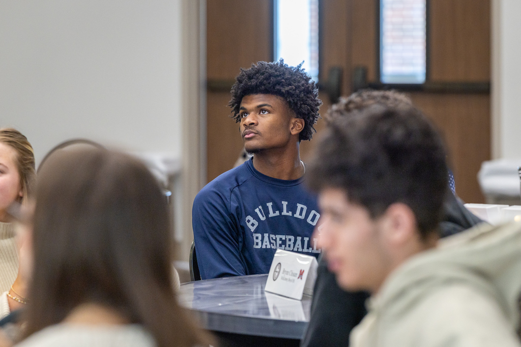 male student looking up in the direction of video screen