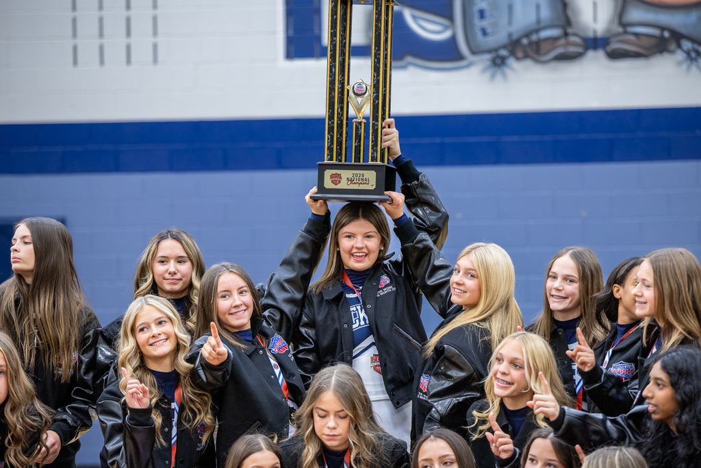 close up of group with girl holding trophy on her head