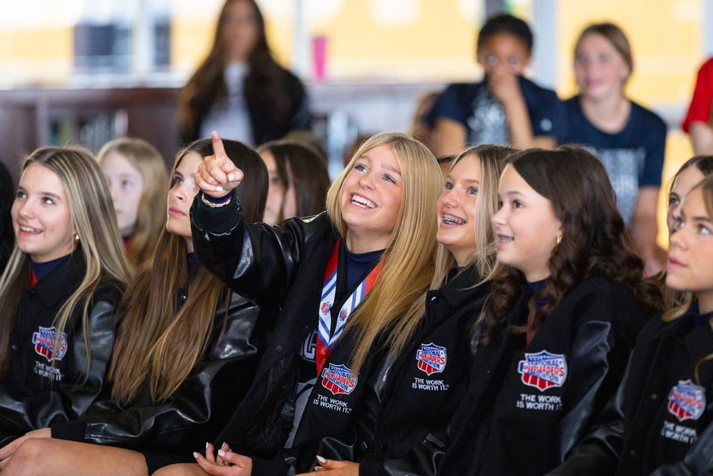 girls sitting and pointing and smiling in reaction to video