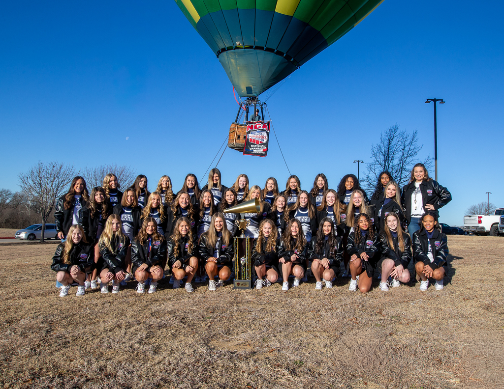team photo with hot air balloon in the background with champions banner on it