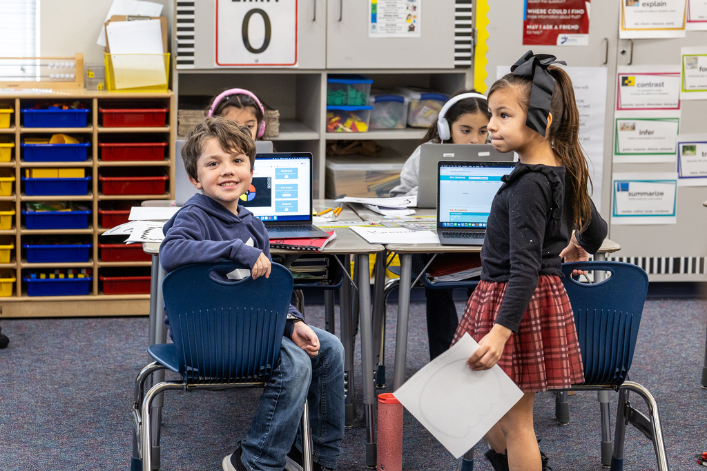 students in class looking at camera and smiling 