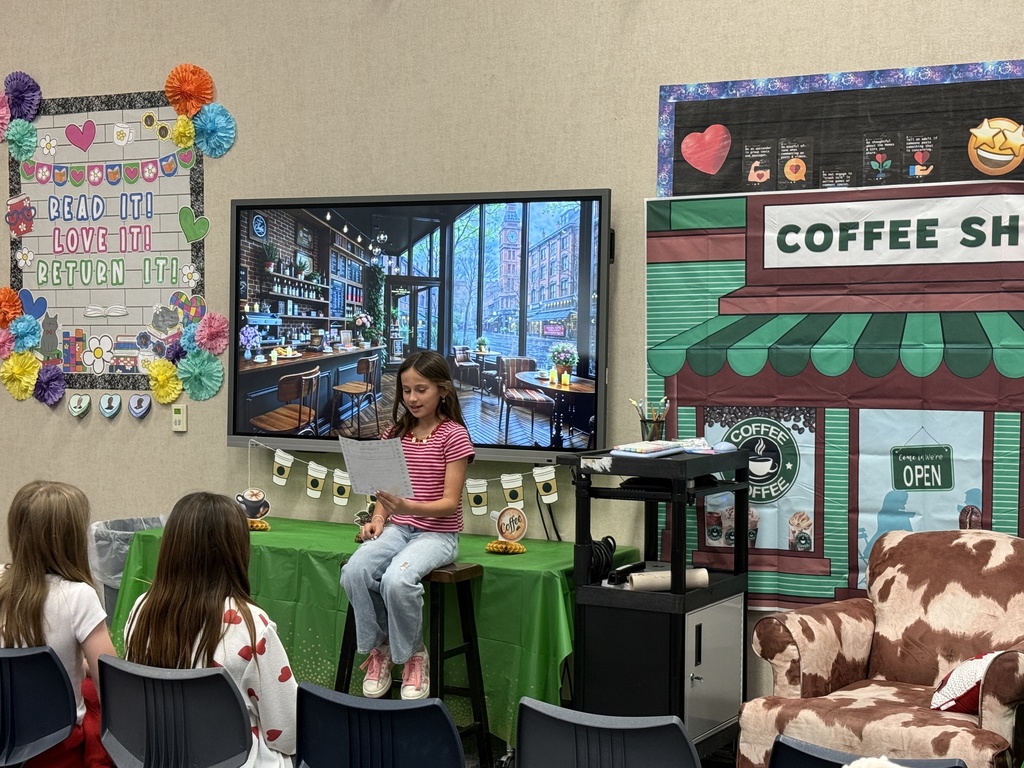 Image featuring a student reading to her peers during the 5th grade poetry cafe.