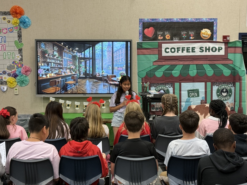 Image featuring a student reading to her peers during the 5th grade poetry cafe.