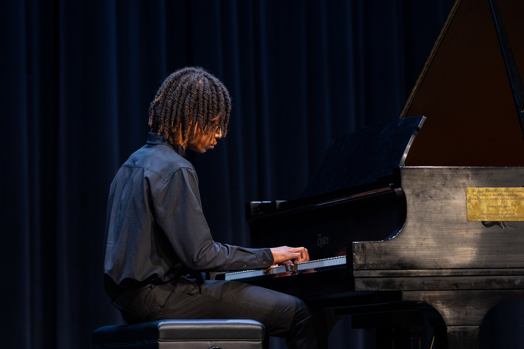 male student playing the piano