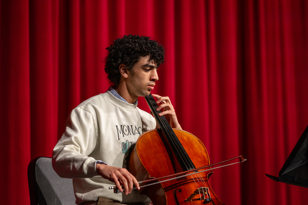 male student onstage playing the cello