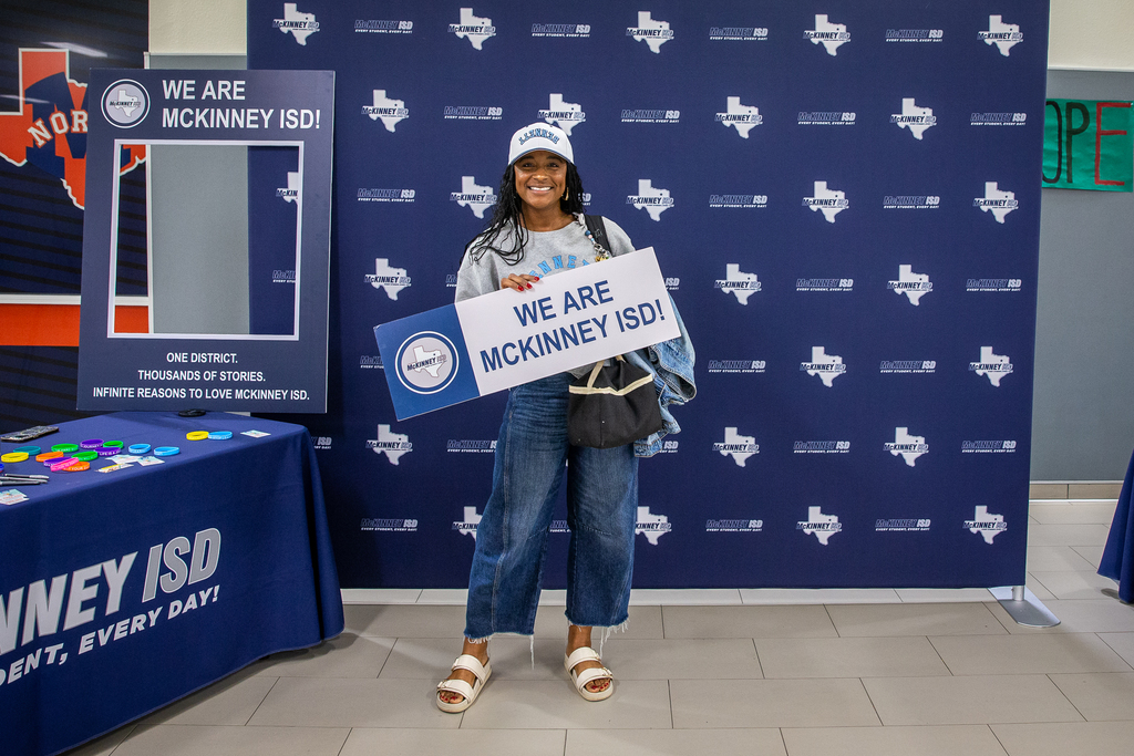 female teacher holding we are mckinney isd sign