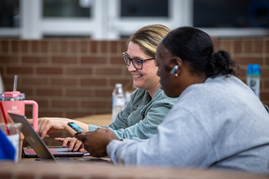 two women working together at table 